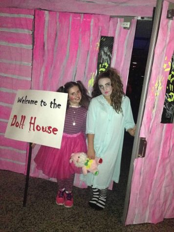 Two students dressed as creepy dolls preparing to welcome in guests into the Gymnasium that was turned into a Doll House for Haunted Hallways.