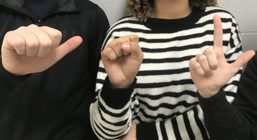 Three Dallastown students spell out the letters A,S,L which stand for American Sign Language. Some schools provide ASL as a world language course. 