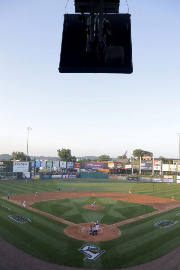 The television seen is the robotic umpire that uses Doppler Radar technology to communicate balls and strikes to the human umpire below on the field