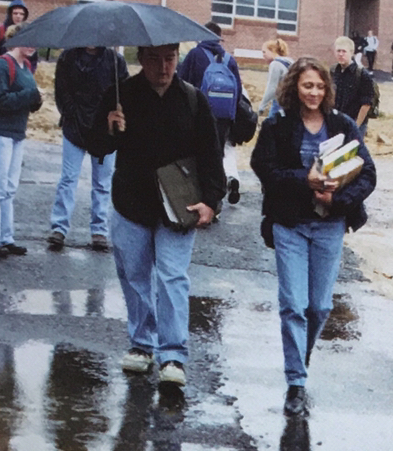Senior Adam Overmiller walks with classmate Bess Atkinson while trying to avoid the rain puddles. Many students had complaints about having to walk in rain or snow in order to get to the temporary pods for class.