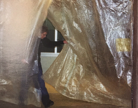 Junior Brian Flynn passes through a plastic wrapping that separates the school from the outside. The active construction altered the walkways, exits and entrances of the school.