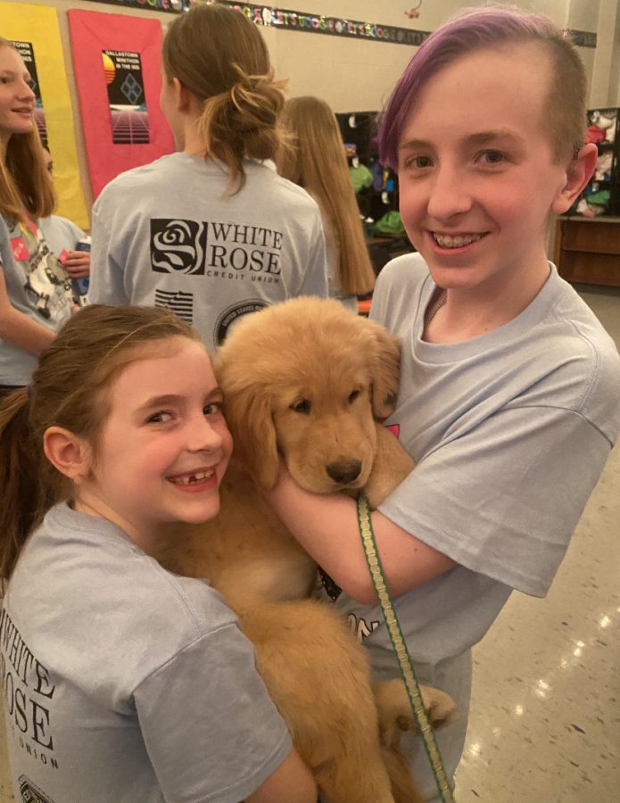 Landon is pictured here with his sister Izzy holding one of the puppies that was in the VIP room during Mini-THON.