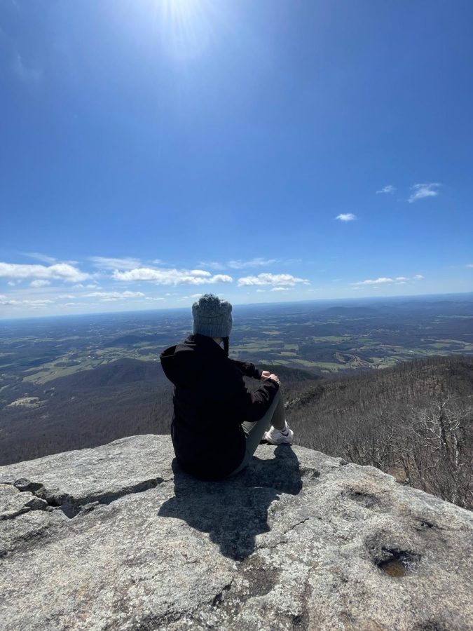 Natalie Cottrell sitting on top of a mountain after hiking in Virginia