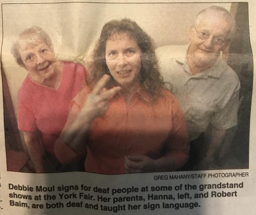 A newspaper article clipping featuring Moul and her parents. 