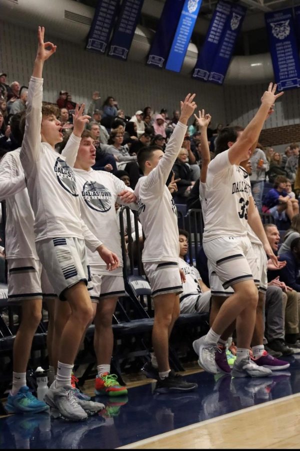 Dallastowns basketball players cheer for their teammates who are currently out on the court.