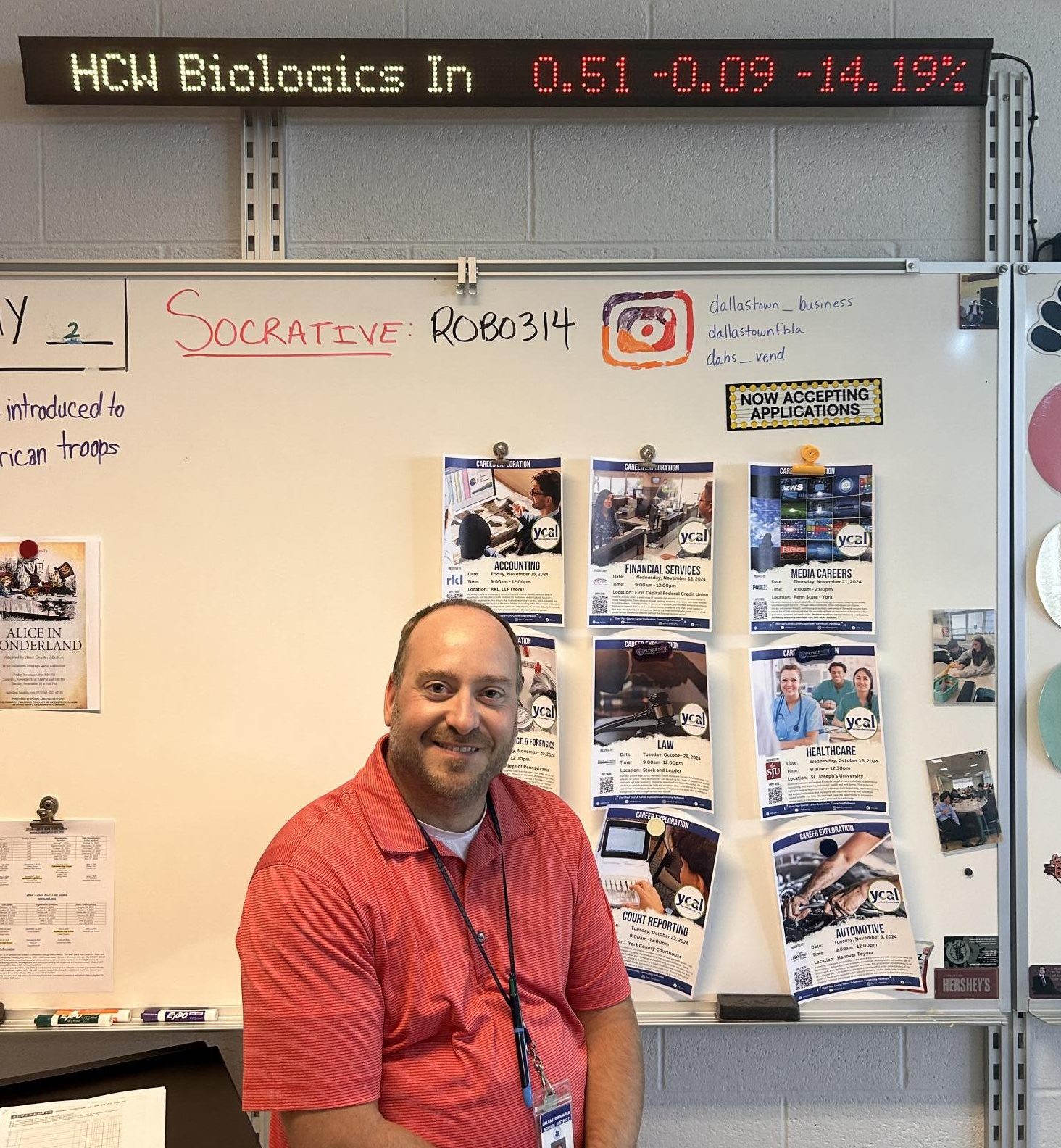 Business teacher in front of stock market ticker