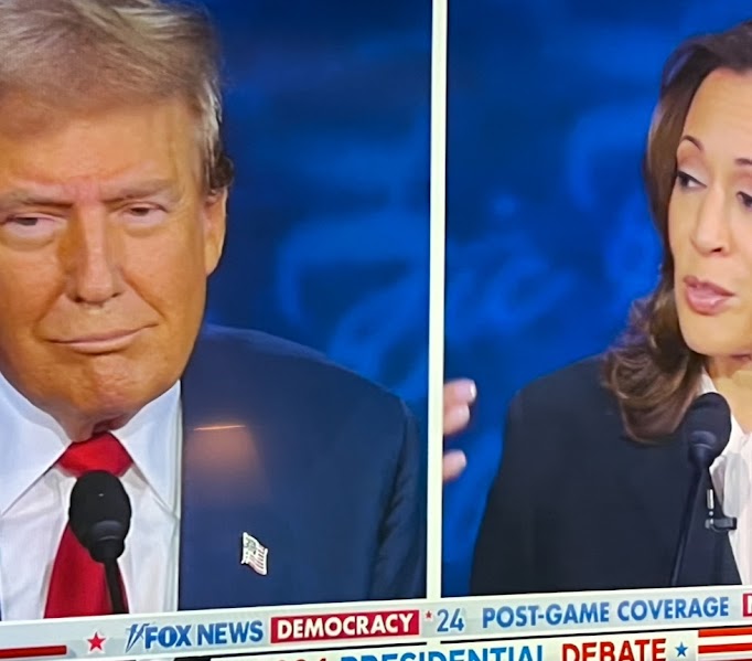 Debate between Donald Trump and Kamala Harris on a TV screen.