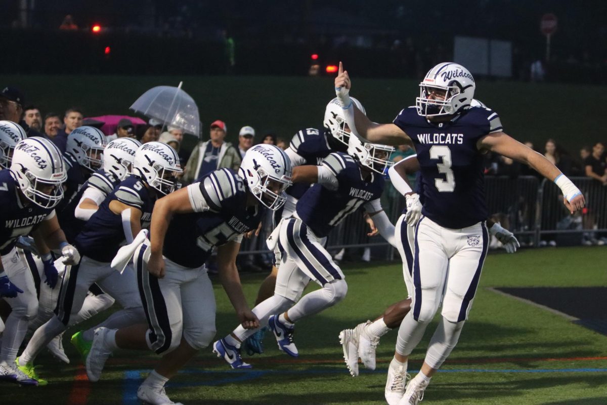 Wildcat football players celebrate as they come onto the field to play the Homecoming game.