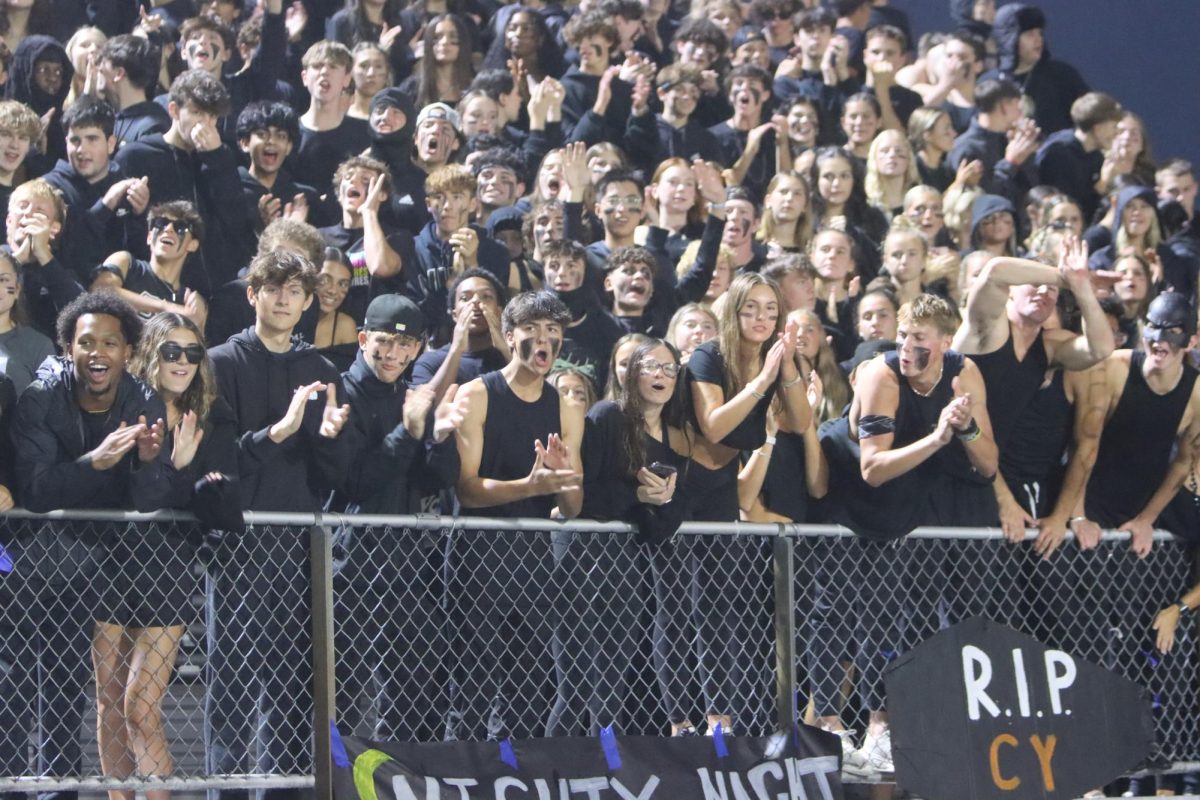 Students watch the game eagerly while cheering.