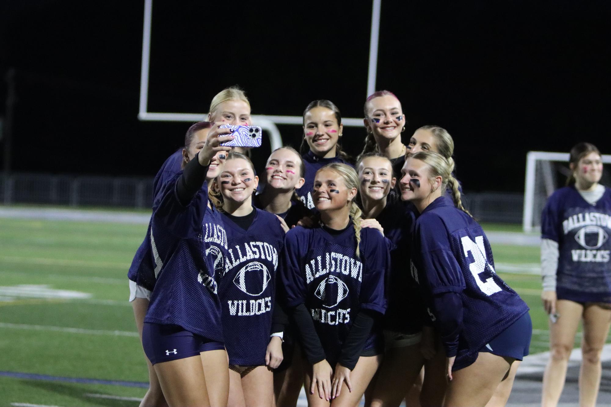 Girls taking a selfie in their Powder Puff uniforms.