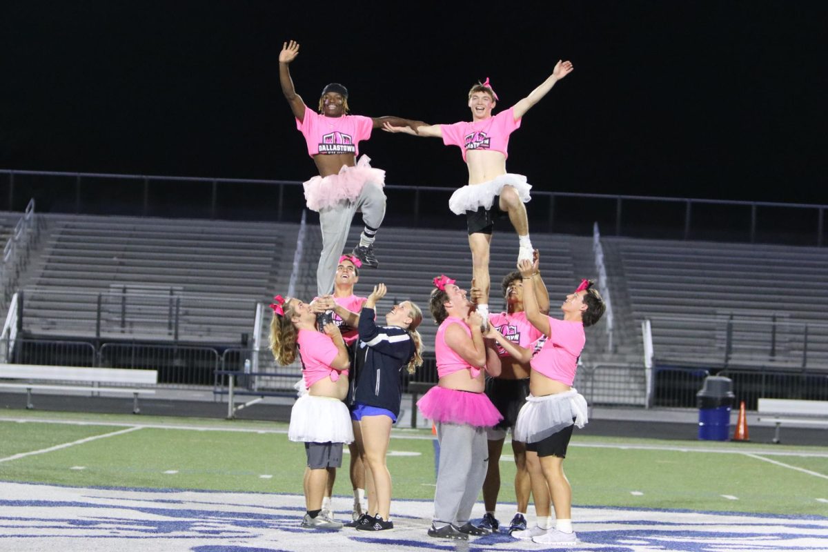 Boys perform stunts, showcasing their cheer skills.