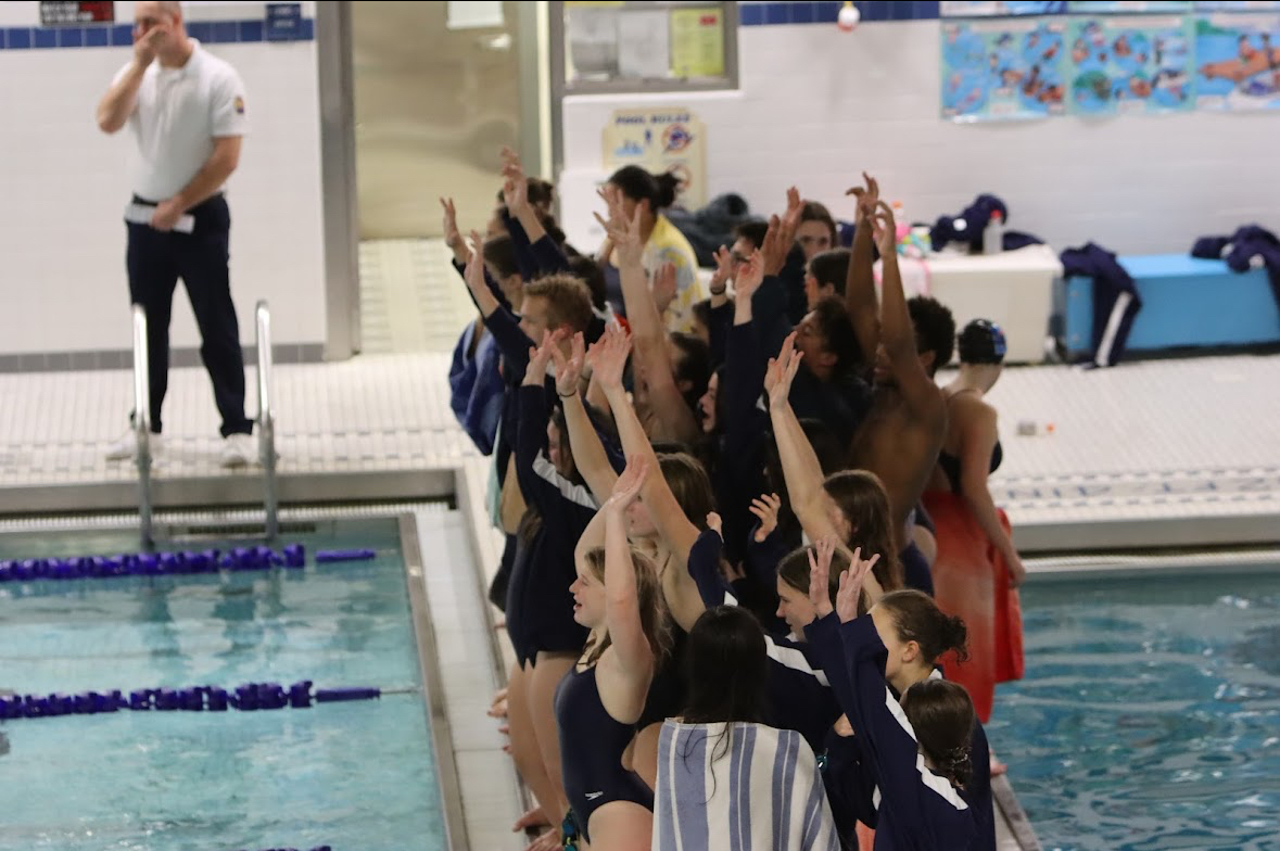 DAHS co-ed girls and boys swimmers cheering on the final relay of the night together.