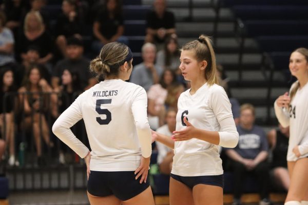 Girls Volleyball teammates talking to each other on the courts.