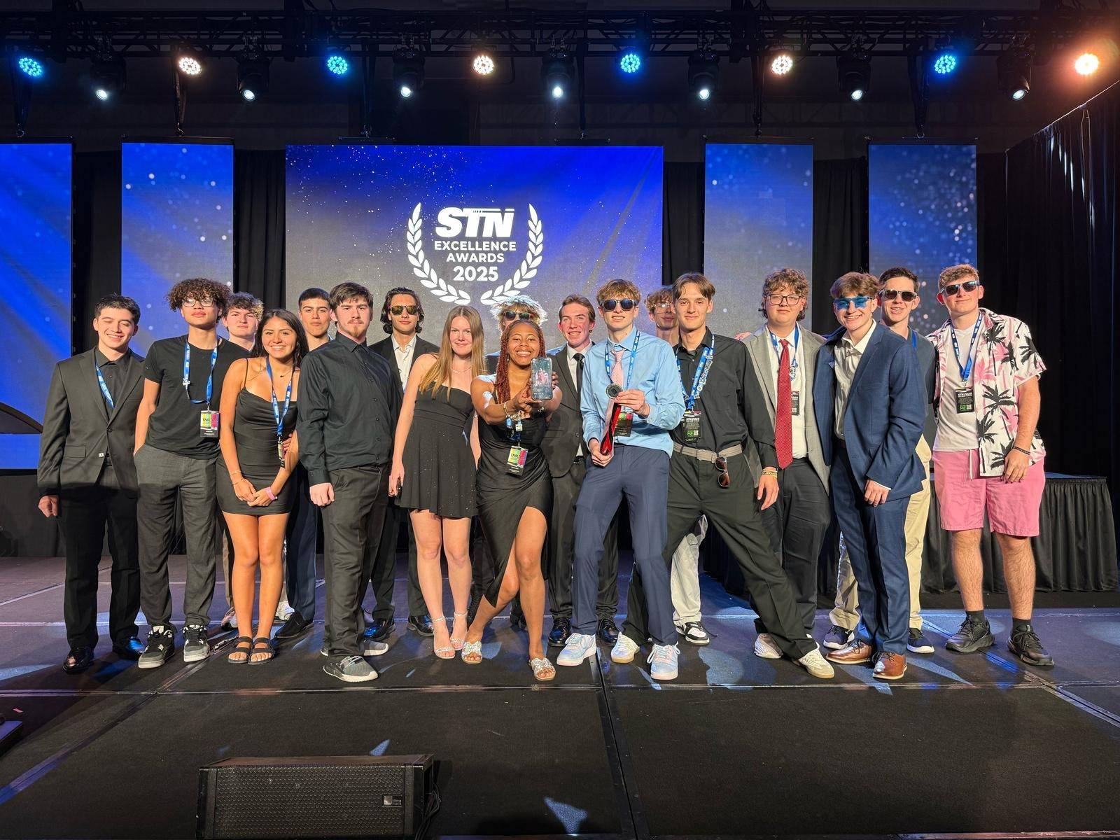 Dallastown Video Production Club after they accepted their Broadcast Excellence award in Tampa. The group holds a photo of former Dallastown VPC adviser Mr. Joe Klinedinst who passed last July unexpectedly. (Mr. Richards)