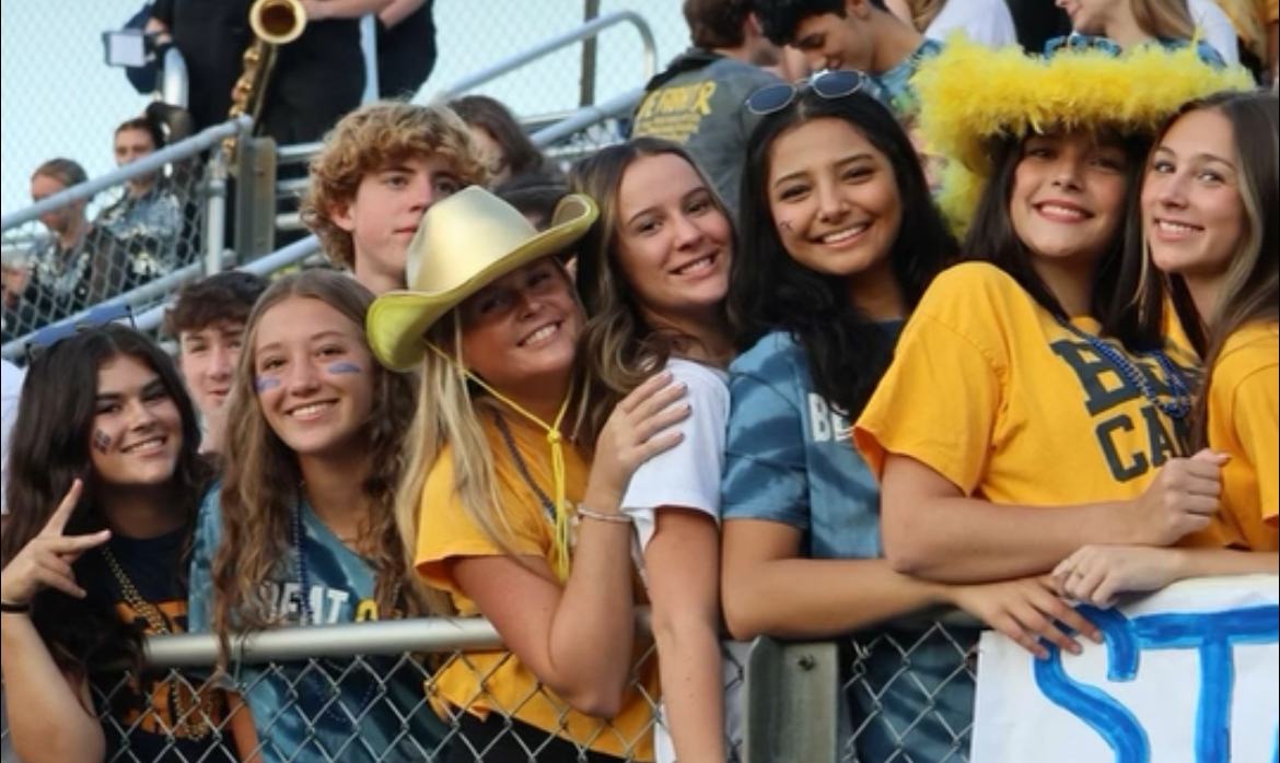 Sophia Long (second from right) smiles with friends Keara Kish, Tatum Berry, Addison Emenheiser, Reese Rosay, Caroline Manning, and Pranjal Ghiraiya at the Beat Cancer football game.