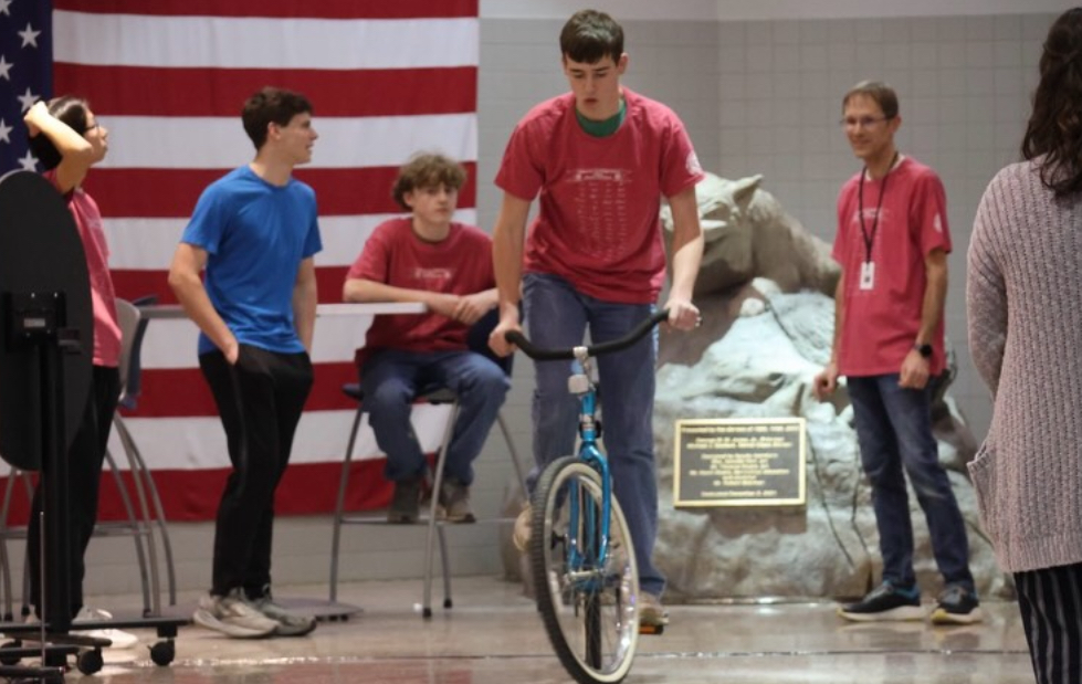 Dallastown students riding a bike while competing in the slow bike race.