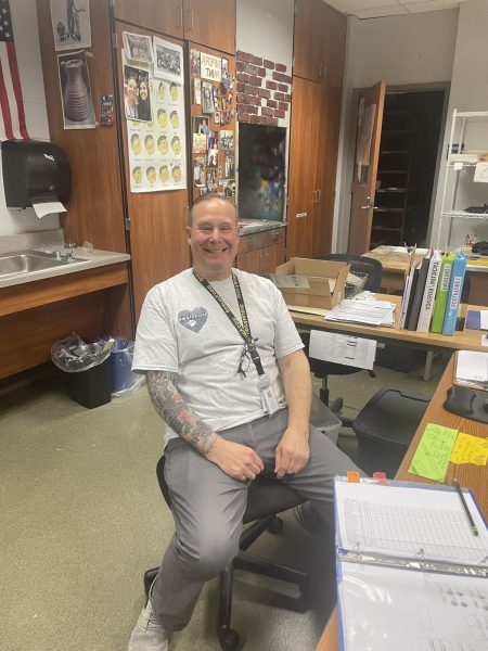DAHS art teacher, Mr. Myers, sits at his desk, smiling in his last few weeks before retirement. 