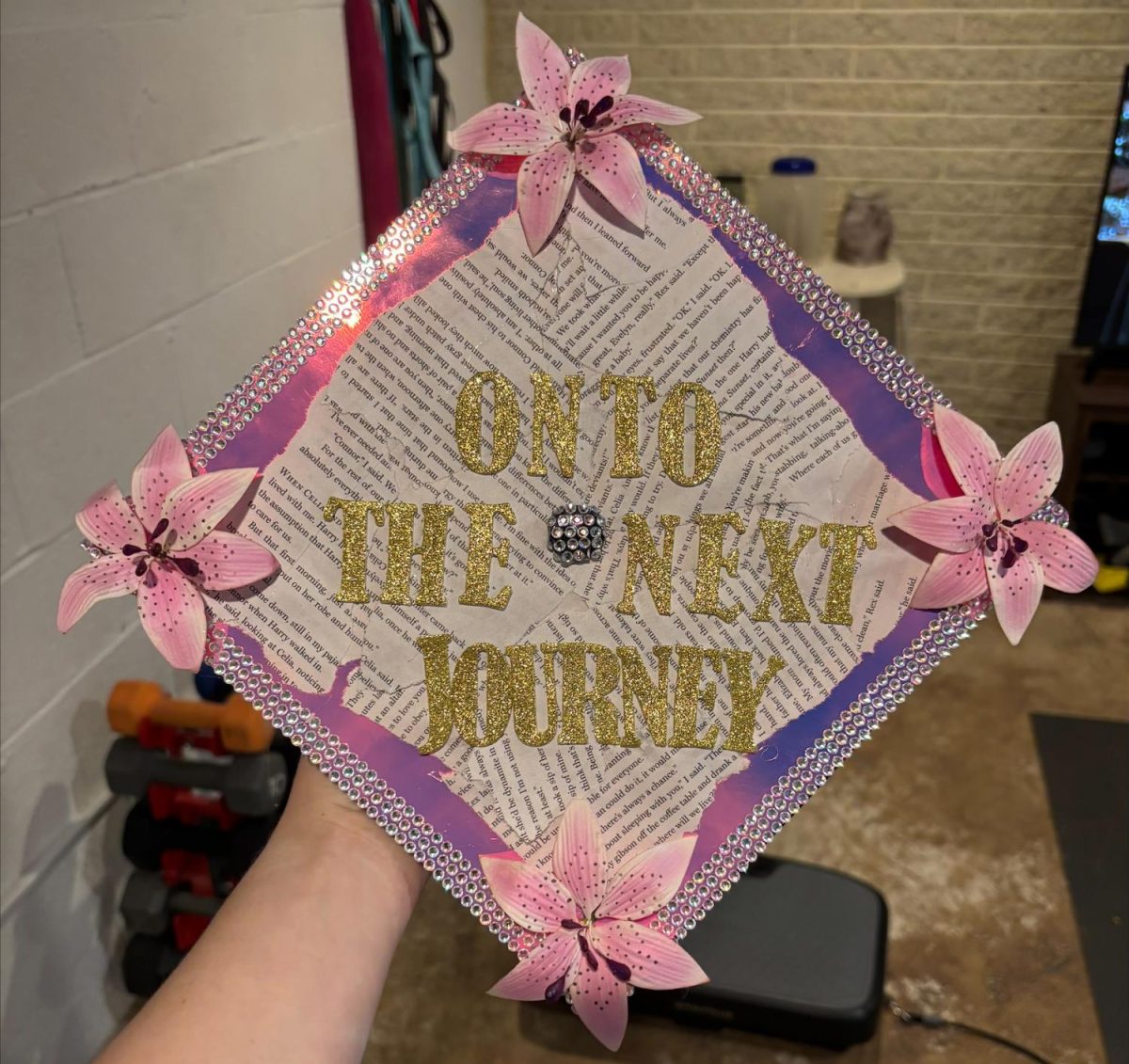 Senior Alyssa Kusmierski shows her flowery decorative cap using torn book pages to show her love for reading throughout her school years
